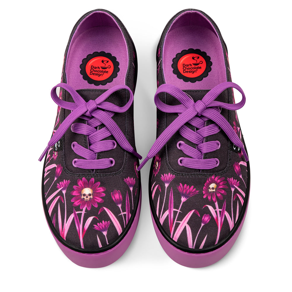 Black sneakers with pink floral patterns and purple laces on a white background