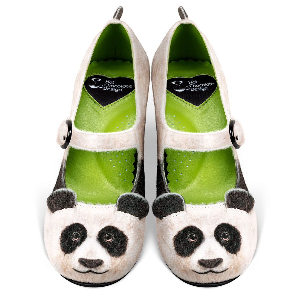 Panda-themed shoes with green soles on a white background