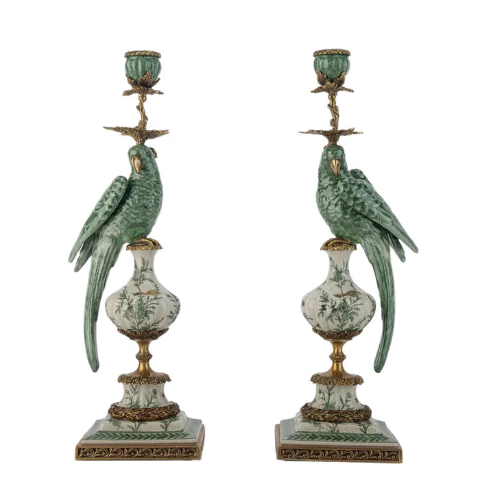 Pair of decorative candle holders with parrot figures on a white background