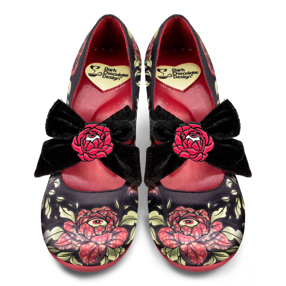 Pair of decorative shoes with floral designs and black bows on a white background