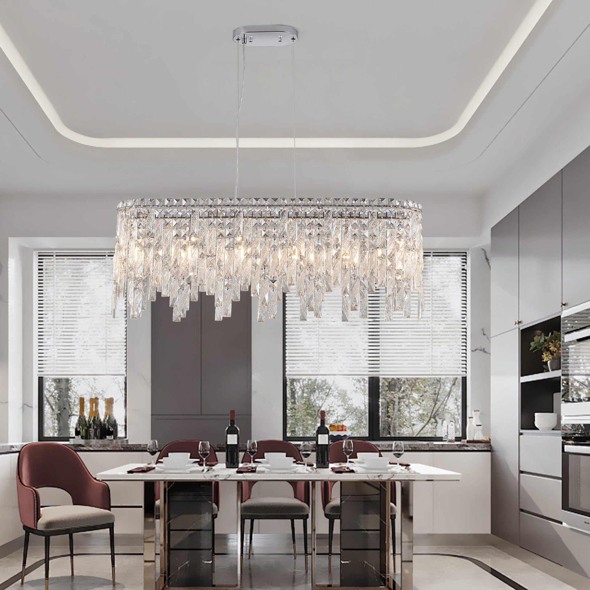 Modern kitchen with a chandelier hanging above a dining table.