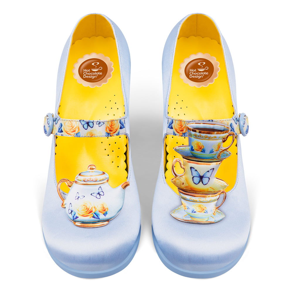 Pair of shoes with tea cup and butterfly design on a white background