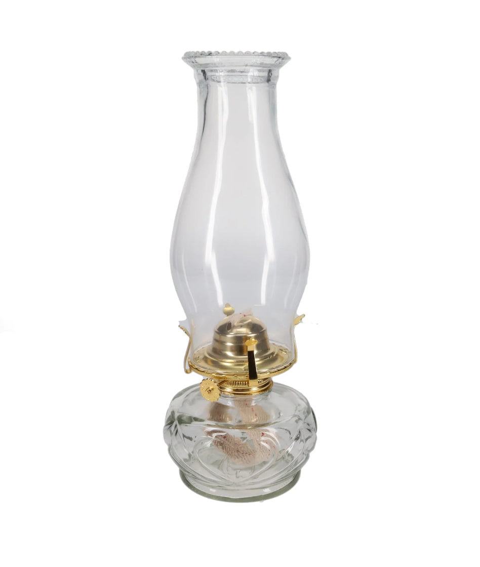 Clear glass oil lamp with brass base on a white background