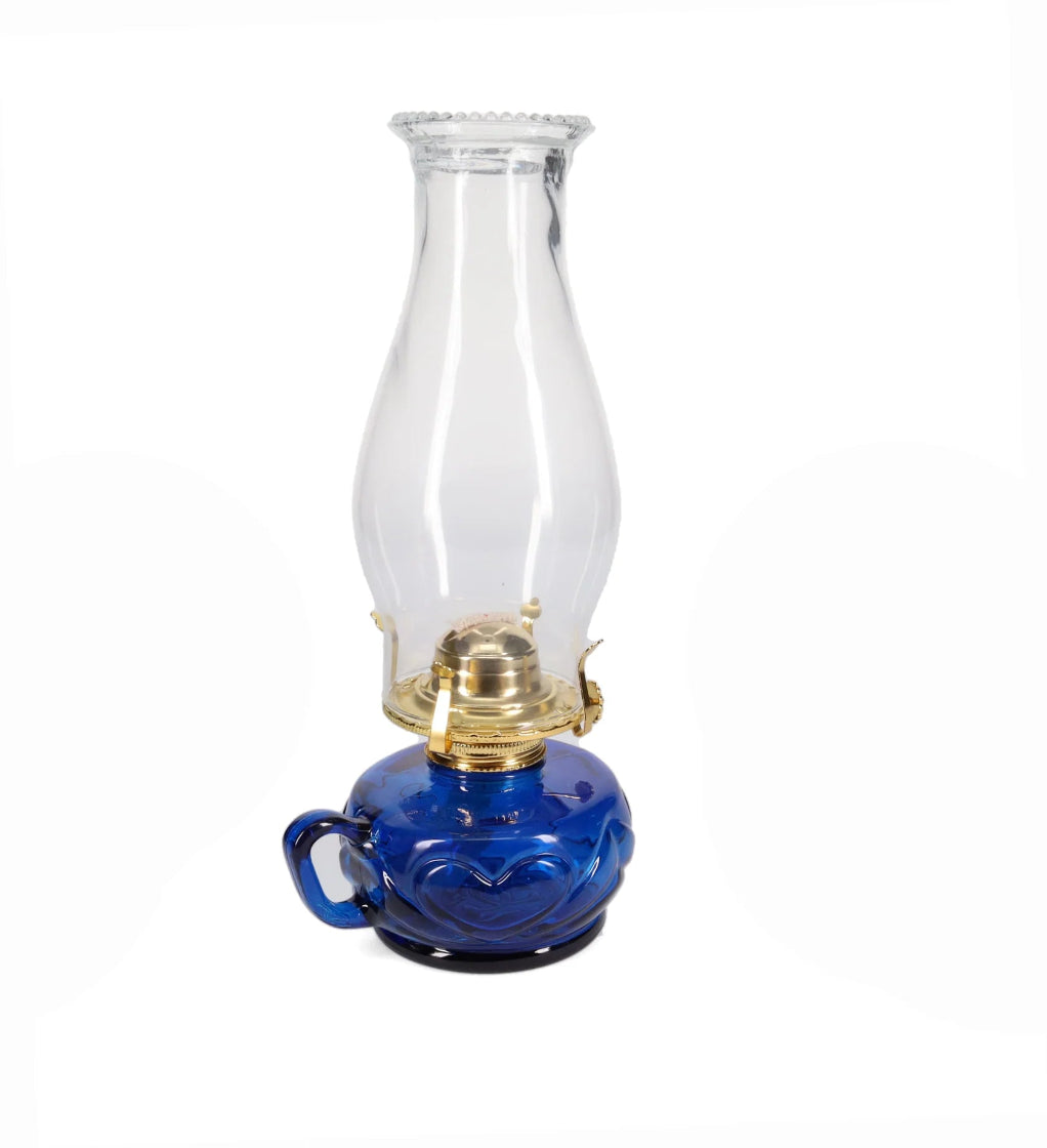 Blue oil lamp with clear glass chimney on a white background