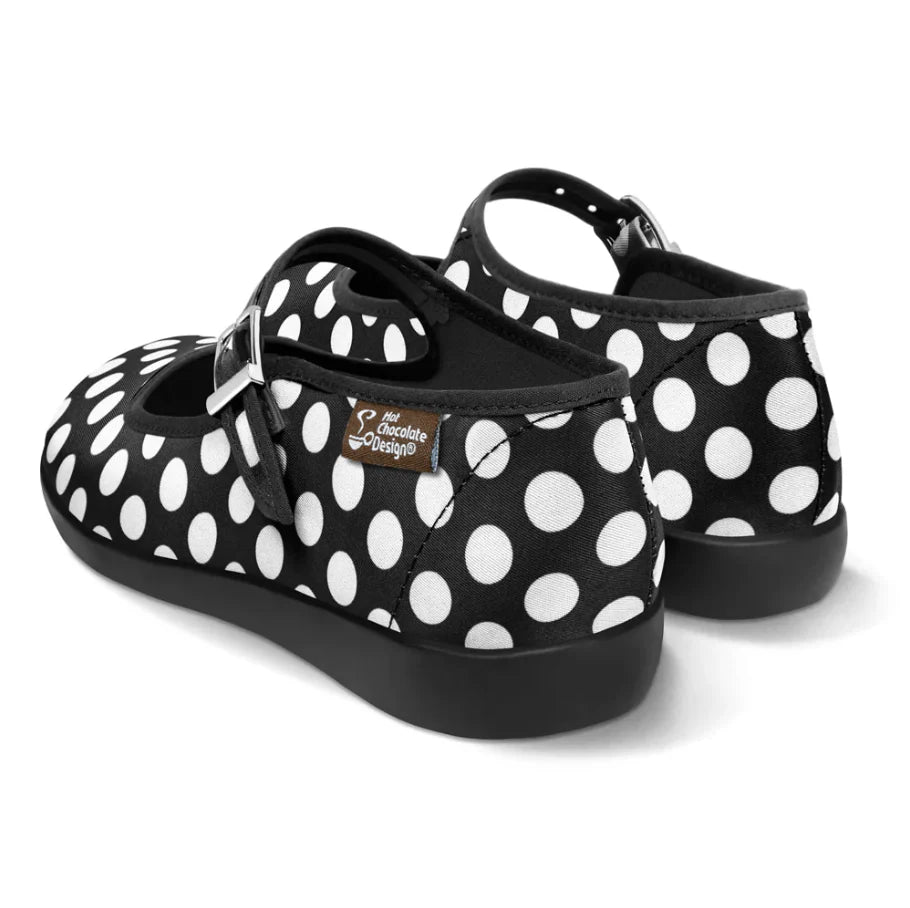Black and white polka dot shoes with a visible brand label on a white background