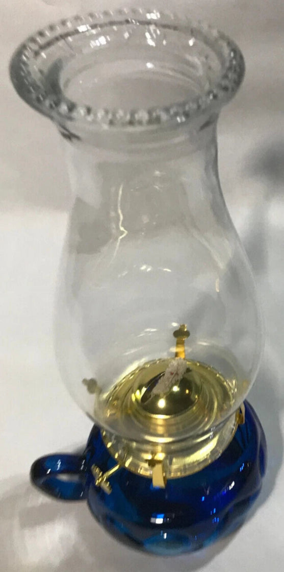 Clear glass oil lamp with blue base on a white background