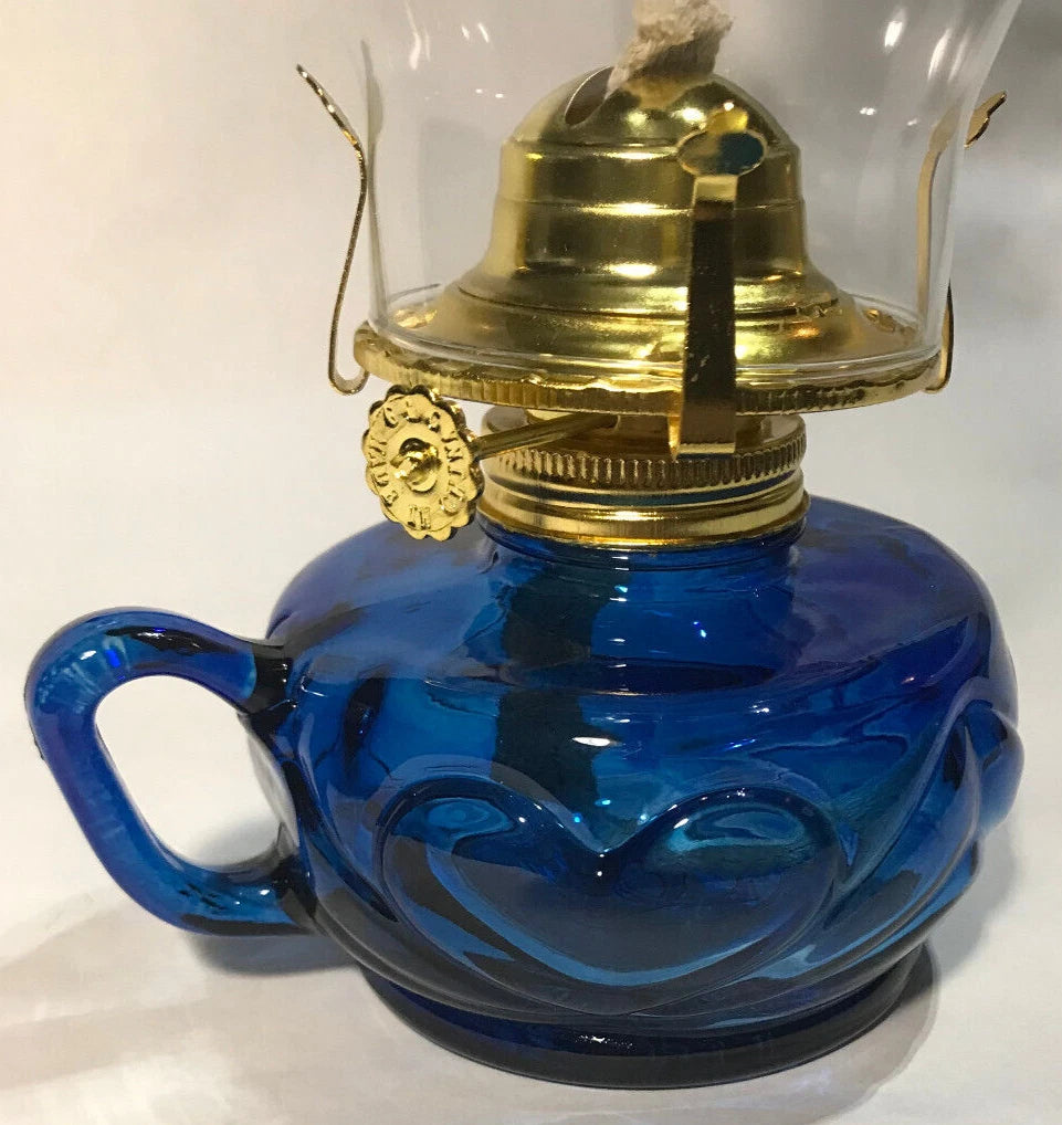 Blue glass oil lamp with brass fitting on a white background