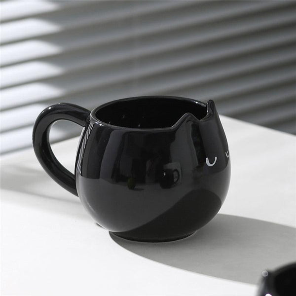 Adorable hand - painted cat - shaped ceramic mug, perfect for coffee or tea.
