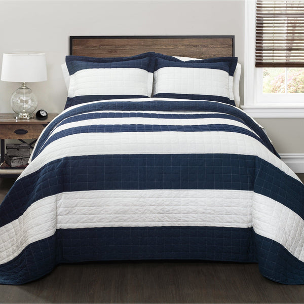 Navy and white striped quilt on a bed in a bedroom setting