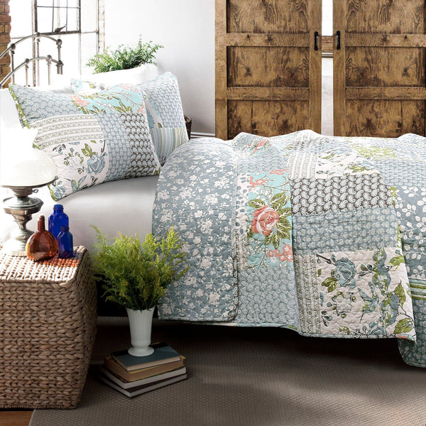 Floral patterned quilt on a bed in a room with wooden doors and decorative items.
