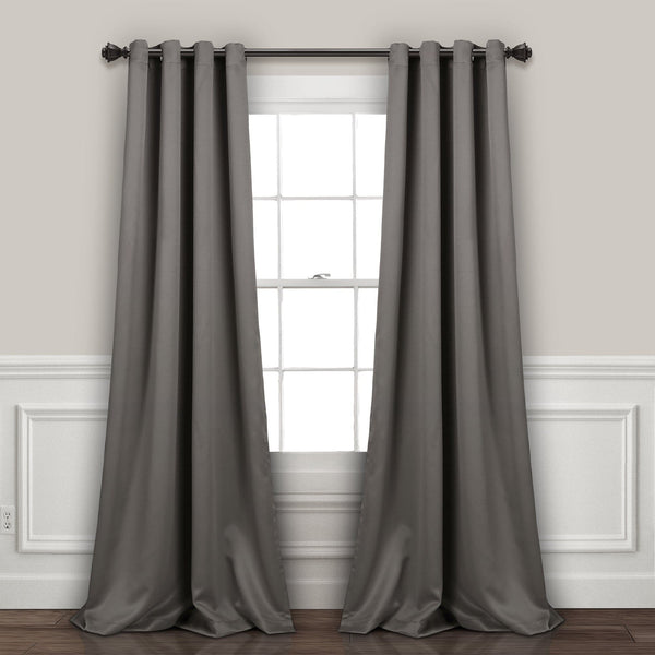 Gray curtains hanging on a window with a neutral wall background