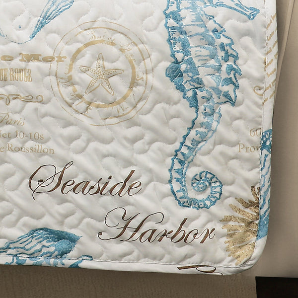 Quilt with seashell and starfish patterns and 'Seaside Harbor' text on a beige background