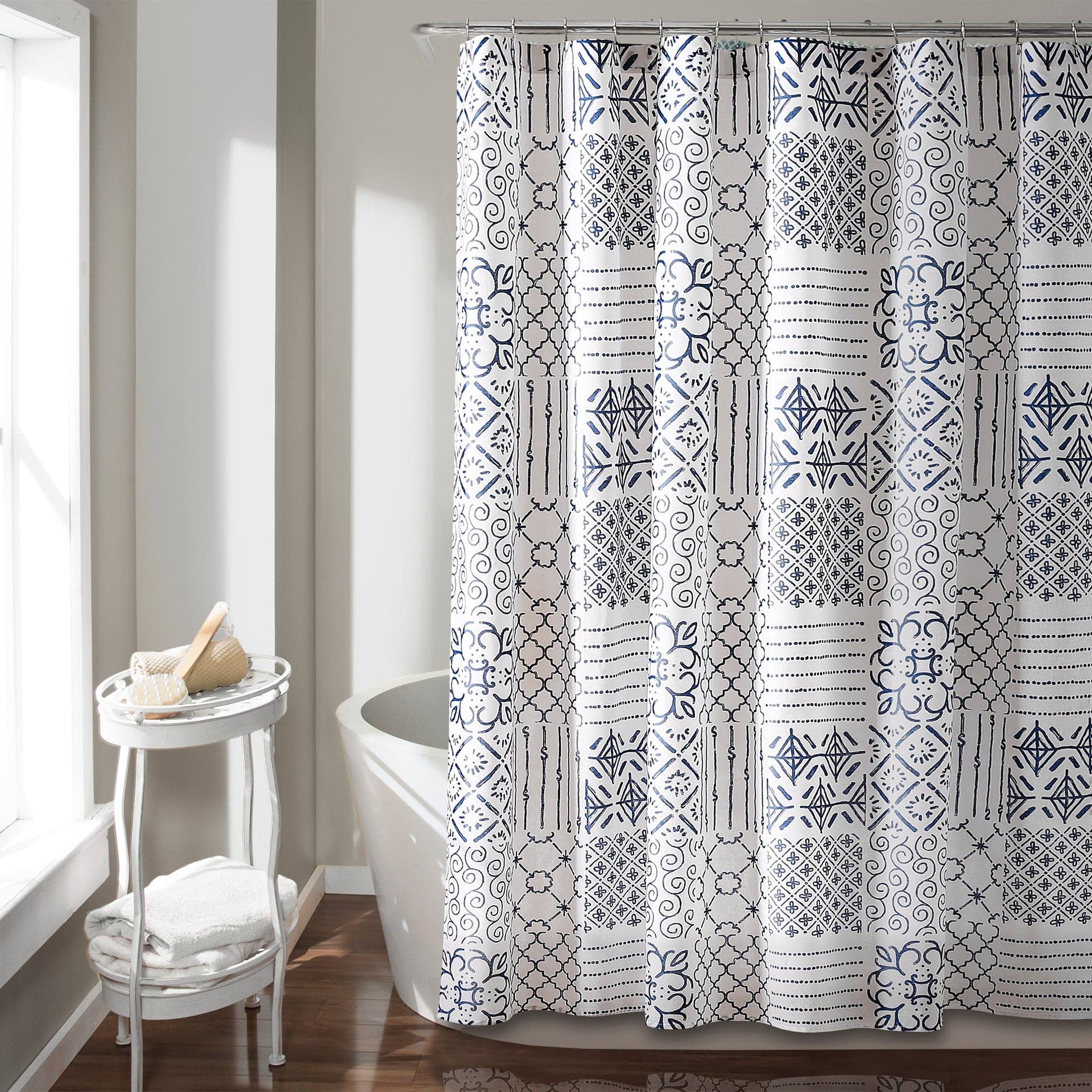Shower curtain with black and white geometric pattern in a bathroom setting