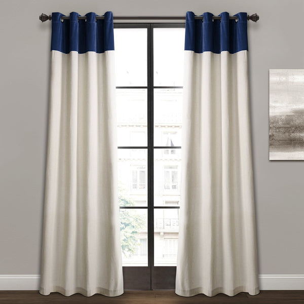 White curtains with blue grommets on a window with a gray wall and abstract painting in the background.