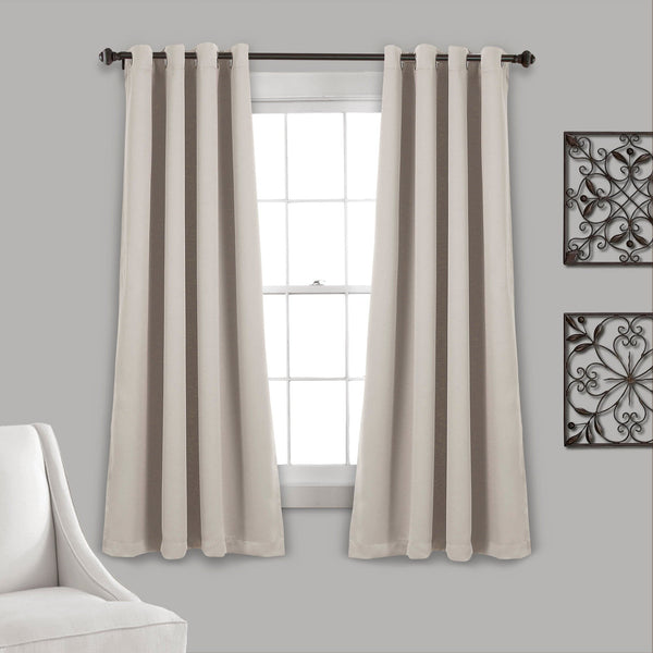 Beige curtains hanging in a window with a gray wall and decorative elements.