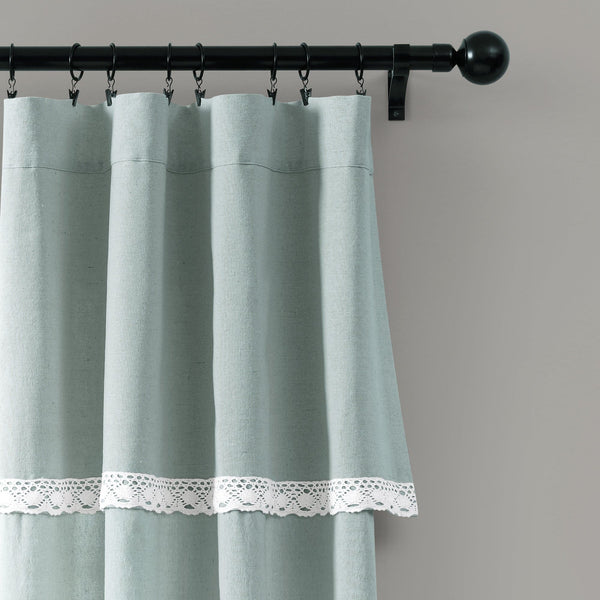 Light blue curtain with lace trim on a gray background