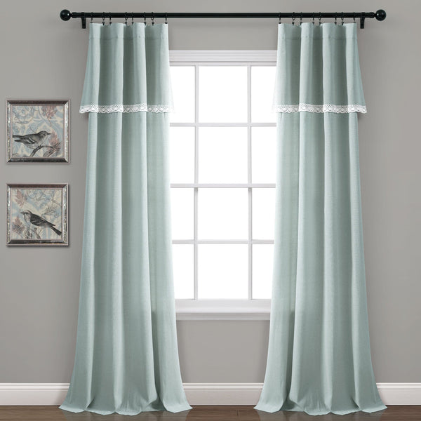 Pair of light blue curtains with lace trim in front of a window.