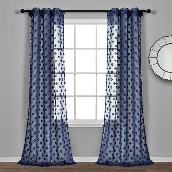 Pair of blue patterned curtains hanging in front of a window with a gray wall and mirror in the background.