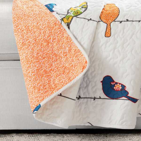 Quilt with bird designs on a couch