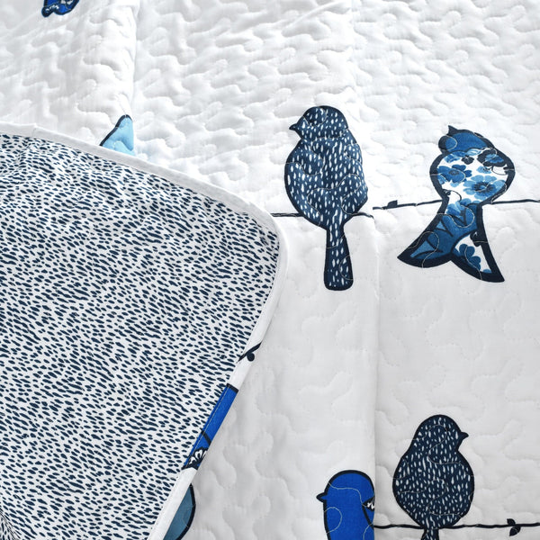 Quilt with blue bird patterns on a white background