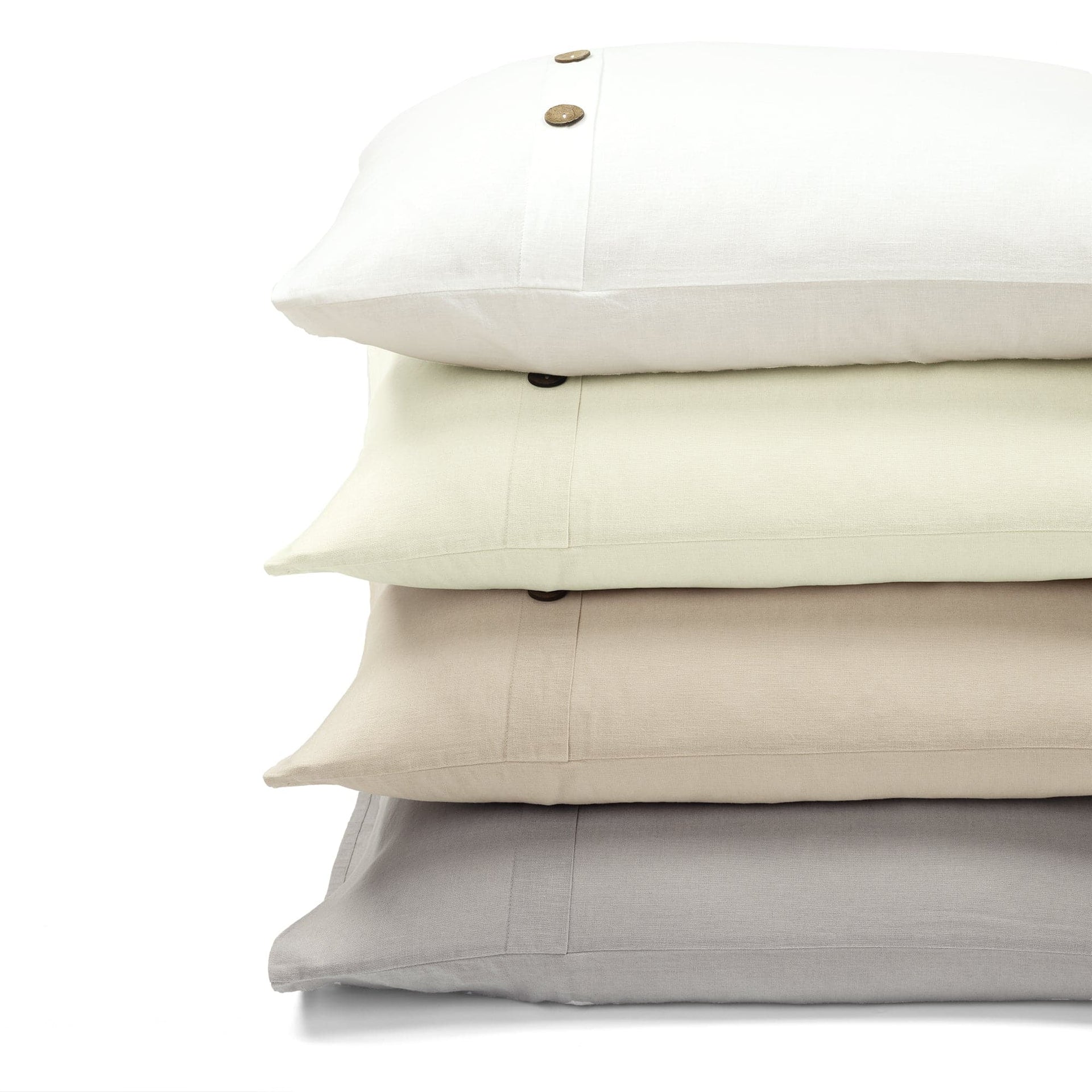 Stack of four pillows in beige, cream, and light gray on a white background