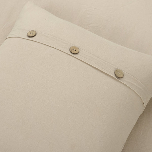 Close-up of beige fabric with buttons on a neutral background