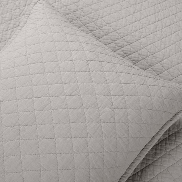 Close-up of a textured gray quilted blanket