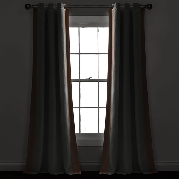 Dark brown curtains hanging in front of a window with a dark room setting
