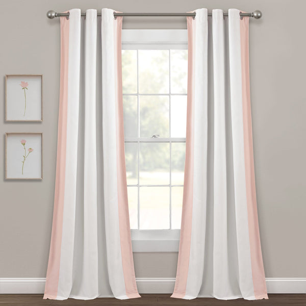 White curtains with pink trim hanging in front of a window with a gray wall and framed pictures in the background.