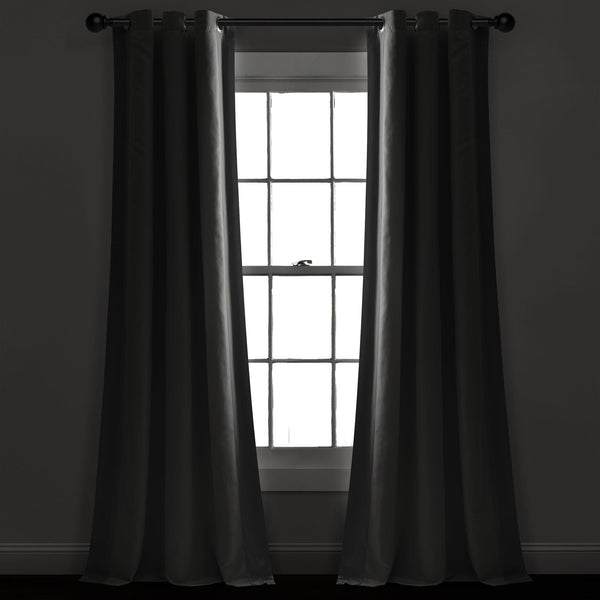 Dark curtains hanging in front of a window with a light background