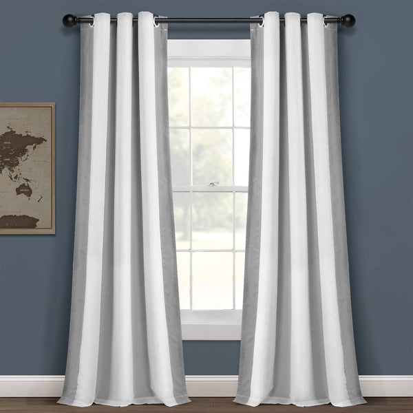White curtains hanging in front of a window with a blue wall and map decor.