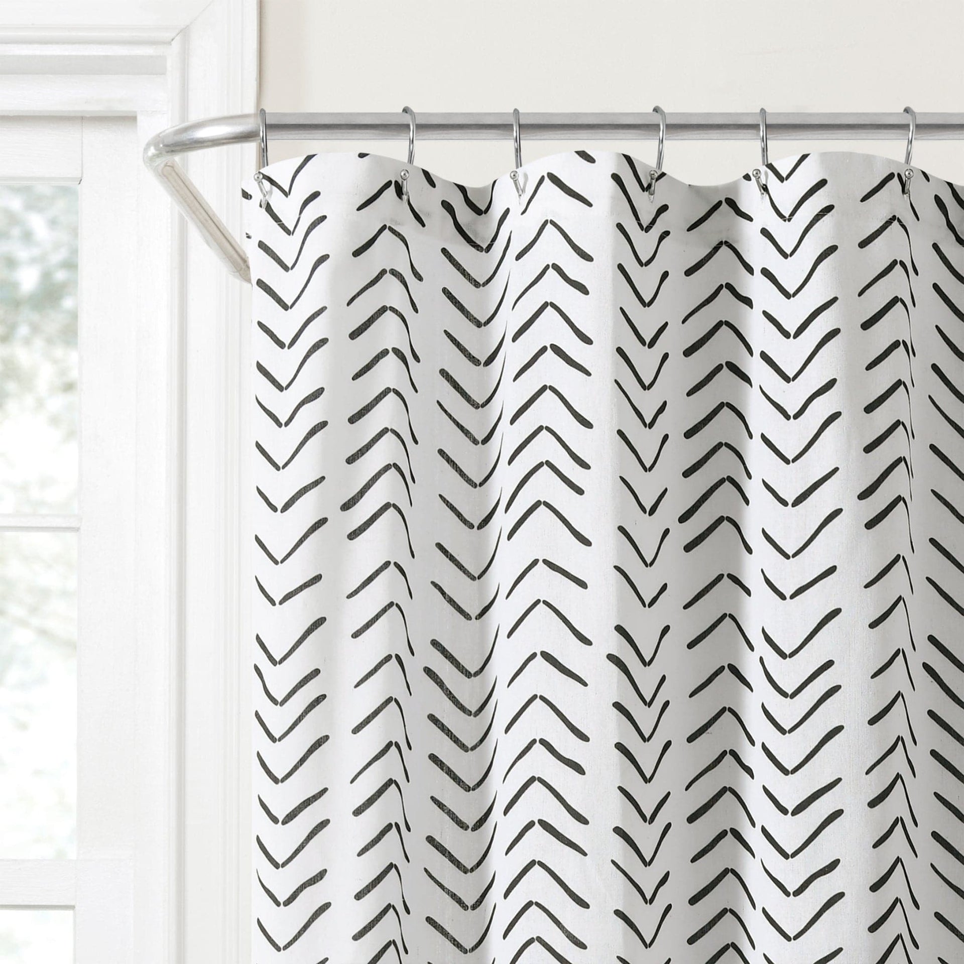 Shower curtain with black chevron pattern on a white background