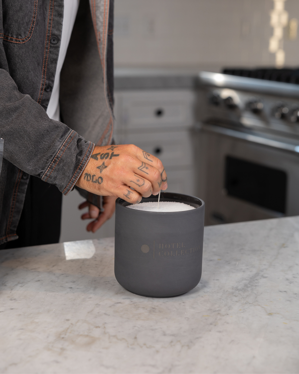 Person using a black container on a kitchen counter with a blurred background