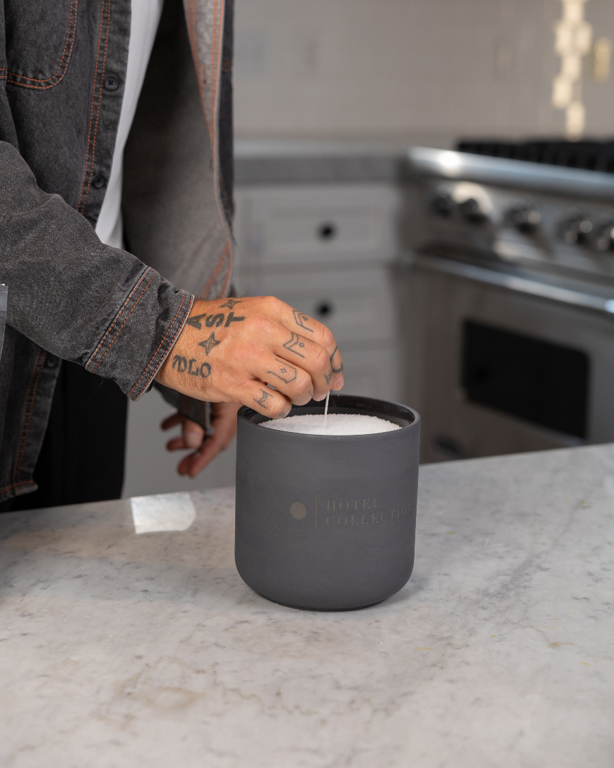 Person using a black container on a kitchen counter with a blurred background