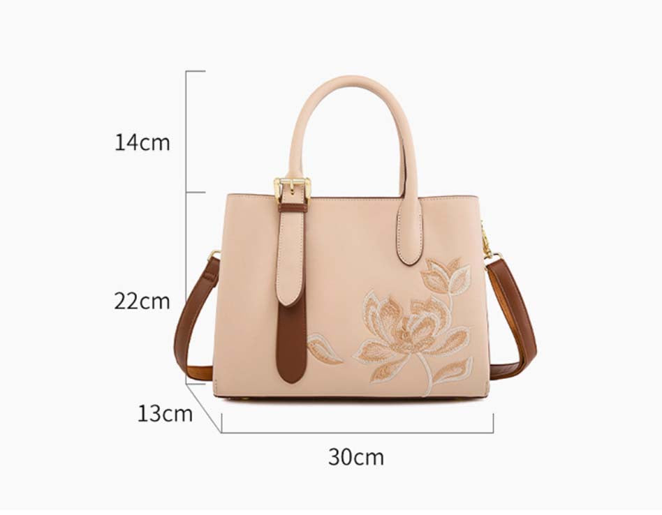 Beige handbag with floral embroidery and measurements on a white background
