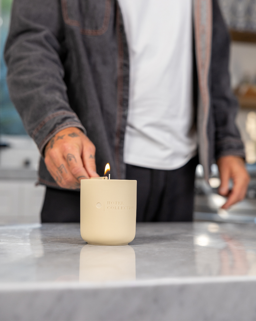 Person lighting a candle on a kitchen counter