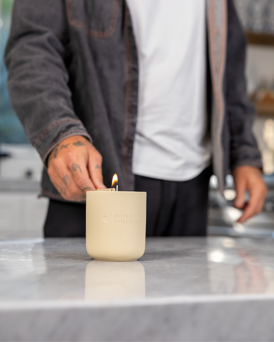 Person lighting a candle on a kitchen counter