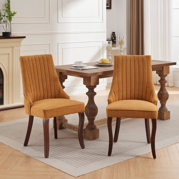 Two mustard yellow Rayon Cloth Flocking Linen Dining Chairs paired with a rustic wooden table in a bright dining room.