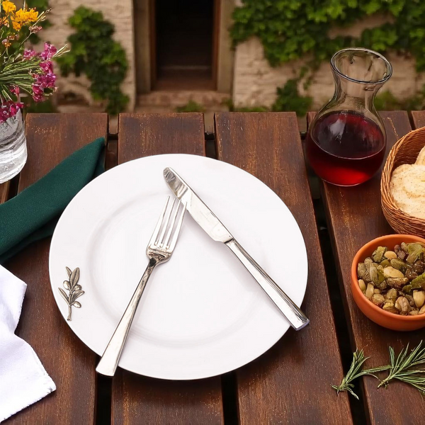 Dining table setup with a plate, fork, knife, and various items on a wooden surface.