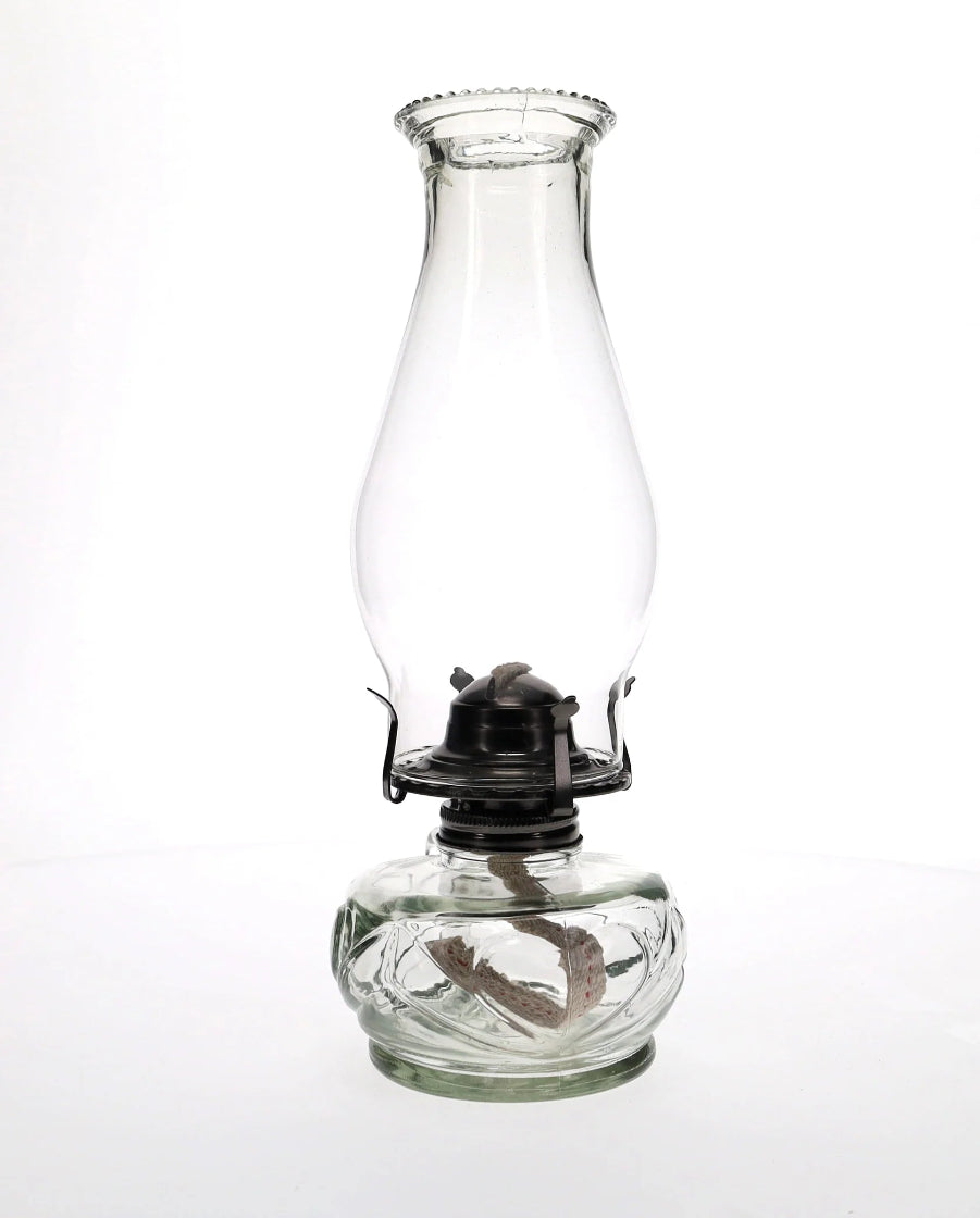 Clear glass oil lamp on a white background