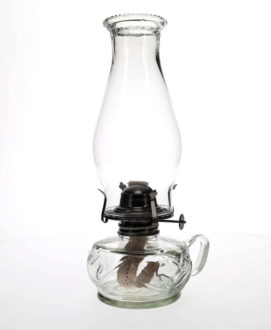 Clear glass oil lamp on a white background