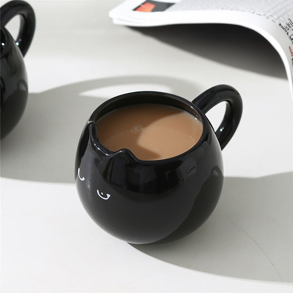 Adorable hand - painted cat - shaped ceramic mug, perfect for coffee or tea.