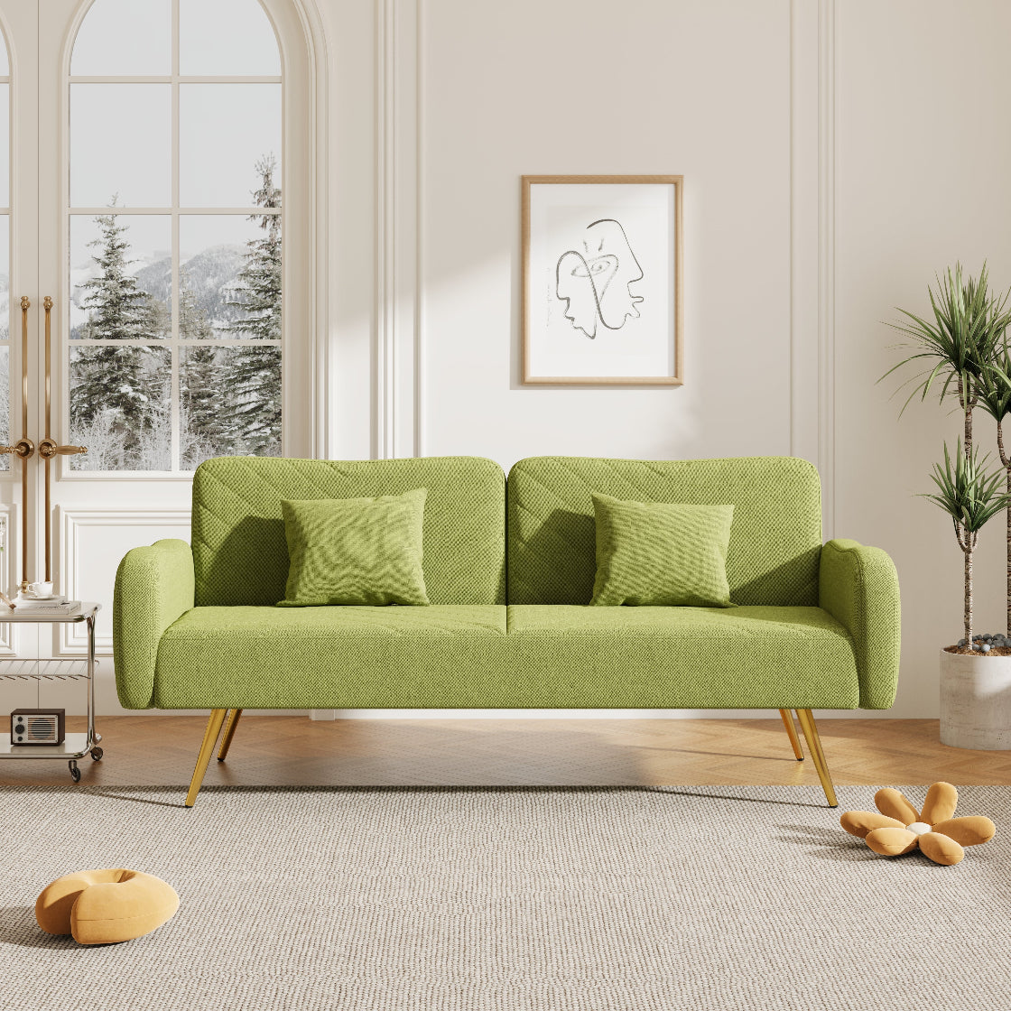 Green sofa in a living room with a window and decorative items.