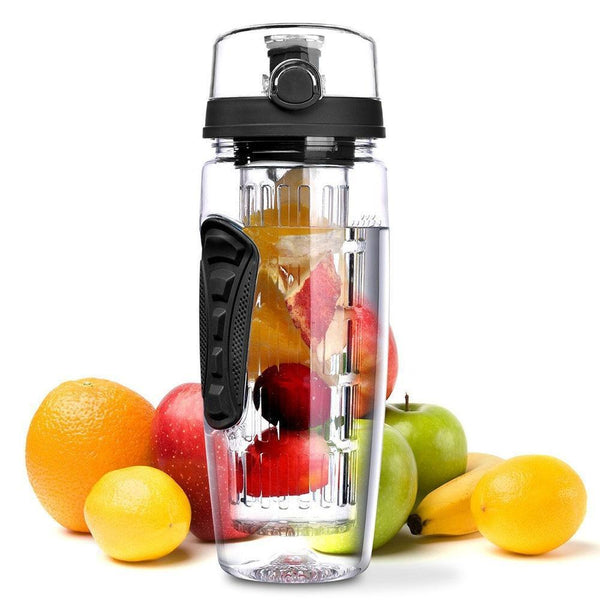 Clear blender bottle with black lid surrounded by fruits on a white background