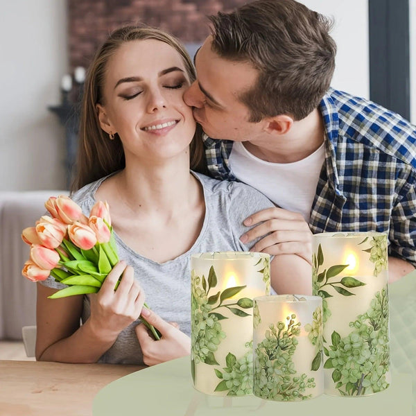 A set of 3 flameless candles, flickering LED pillar candles, with a 10-button remote control. They feature a green floral theme, are suitable for spring and summer, and can be used on the dining tables at wedding venues