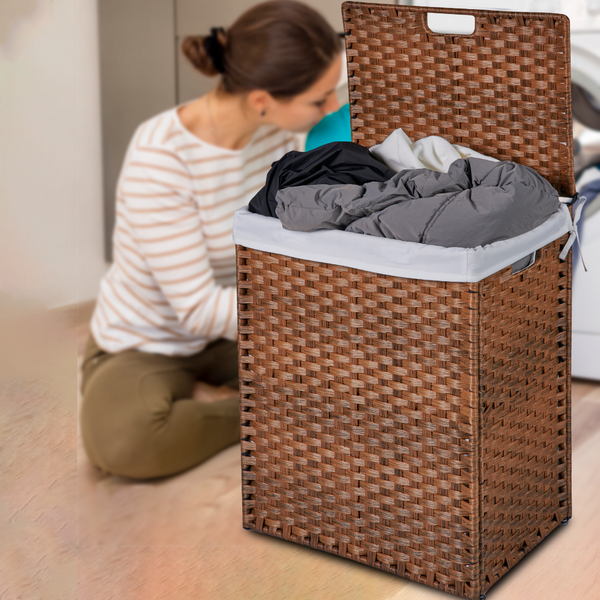 Woman sorting laundry next to a woven laundry basket filled with clothes.