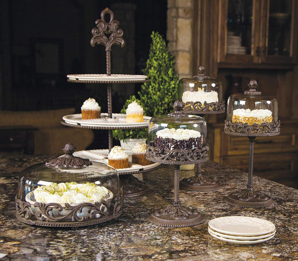 Acanthus Stoneware Pie Server with Dome. Decorative cake stands with cupcakes and candles on a marble surface.