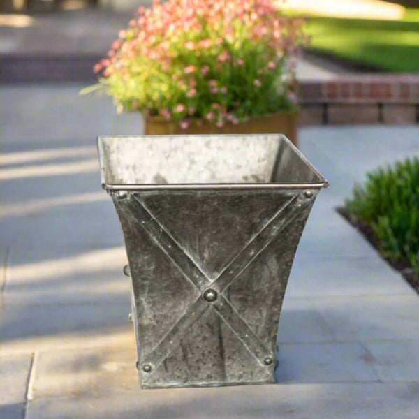 Metal planter with decorative crossbars on a patio