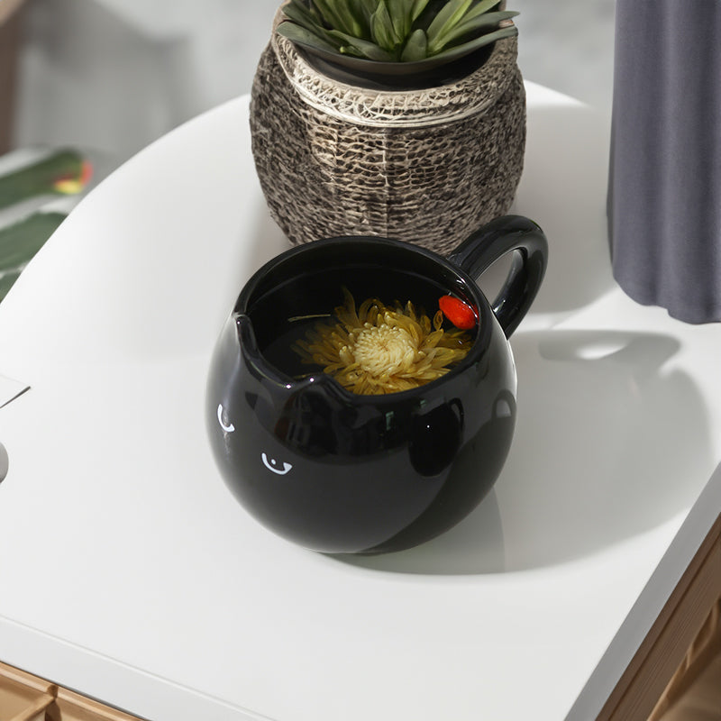 Adorable hand - painted cat - shaped ceramic mug, perfect for coffee or tea.