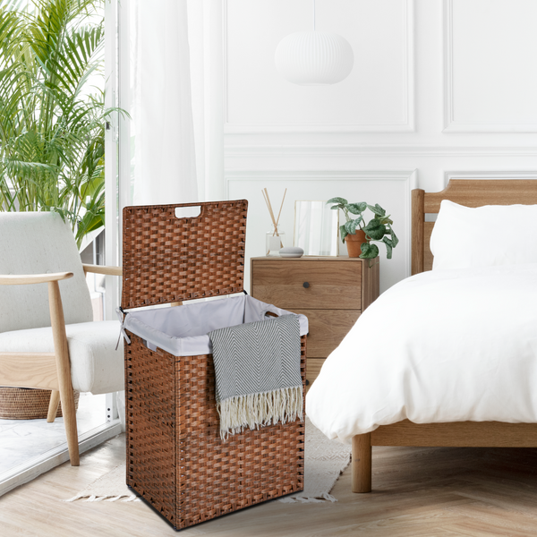 Wicker laundry basket in a bedroom with a bed, nightstand, and chair.